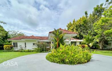 Covered terrace with outdoor bar overlooking garden and pool in tropical beach house Santa Clara Panama