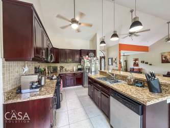 Beach house with white walls, garden, and red tile roof in quiet Santa Clara Panama neighborhood