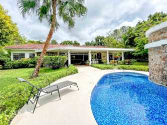 Swimming pool surrounded by lush greenery and sun deck at Panama beach house for sale Santa Clara