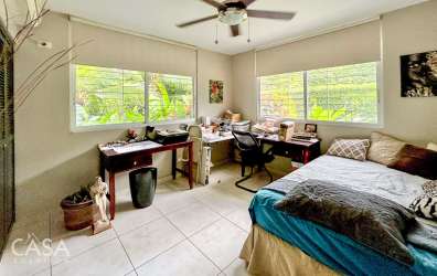 Large single-story beach house with red tile roof, carport, garden and circular driveway in Santa Clara Panama