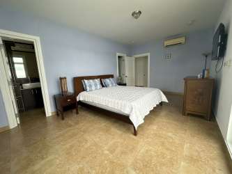 Spacious master bedroom with ensuite bathroom, AC and tile flooring at PH Miramar Panama beach condo