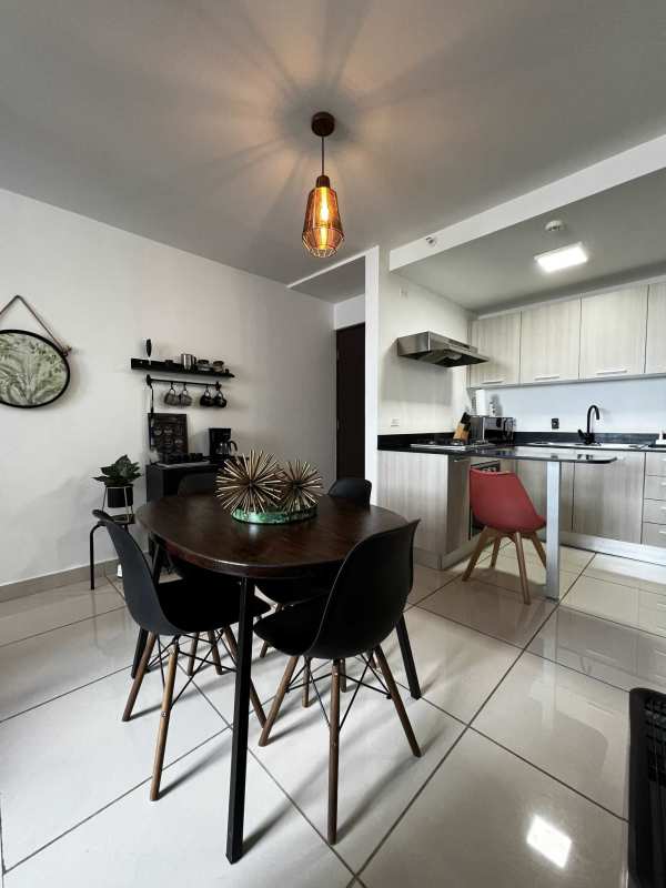 Dining space with round table and modern kitchen with breakfast bar in PH Mi Condado Panama