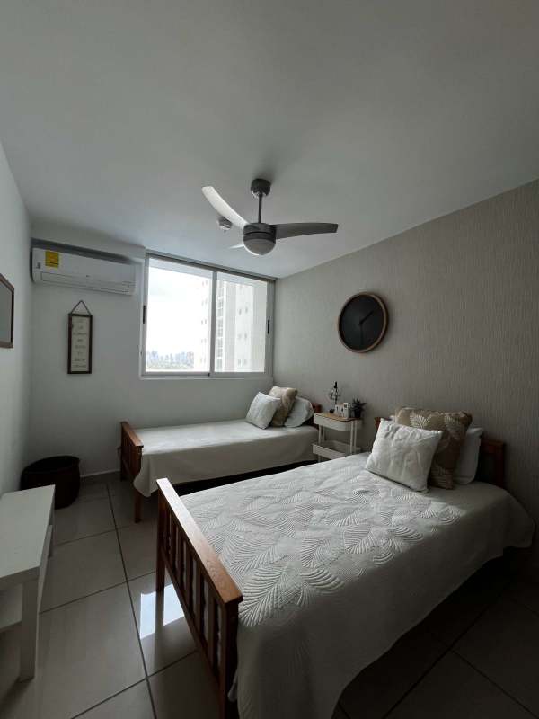 Bedroom with large window AC and ceiling fan in PH Mi Condado apartment Panama City