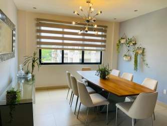 Dining room area with large window and stylish furnishings in River Valley condo Panama Pacifico
