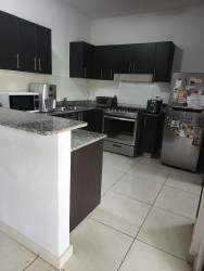 Modern living and dining area with windows and access to the terrace in Woodlands Panama Pacifico