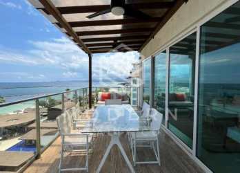 Bright open-plan living room with floor-to-ceiling windows and stunning ocean views in Playa Escondida condo