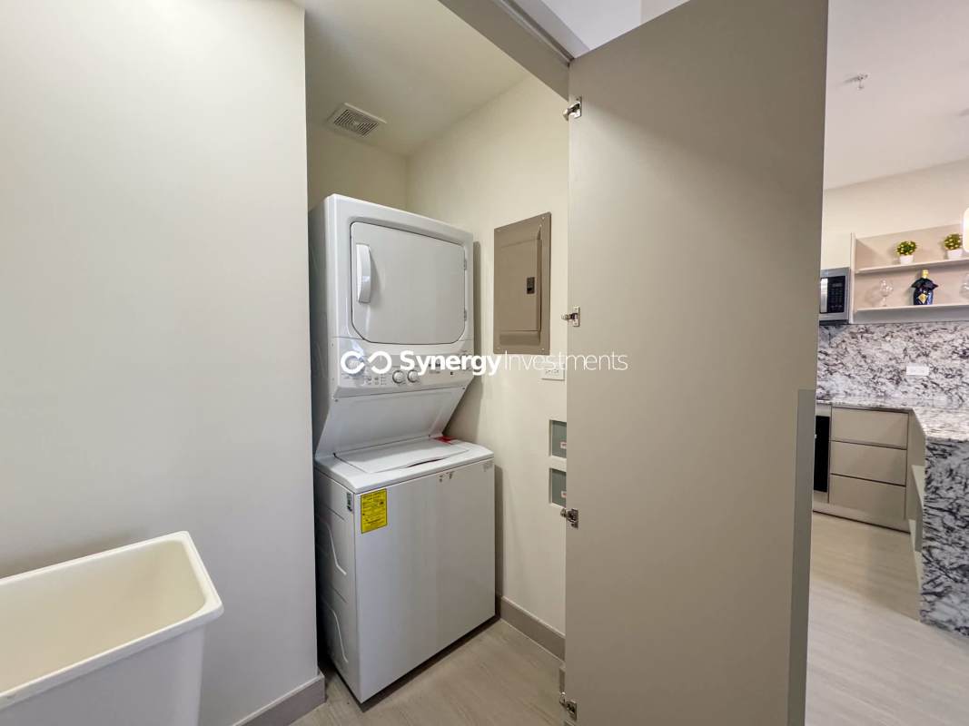 Modern kitchen with marble countertop island, pendant lights and dining space at PH Costa del Este Residences Panama City