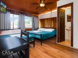 Rustic hotel guest room featuring wood ceiling, large windows with mountain scenery in Boquete Panama
