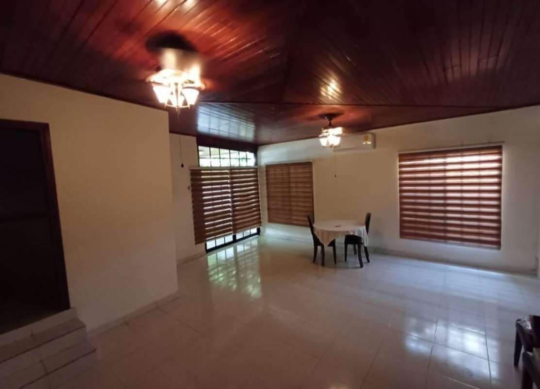 Dining area with traditional wooden ceiling, tiled floor, minimal furniture in commercial-residential house San Francisco Panama