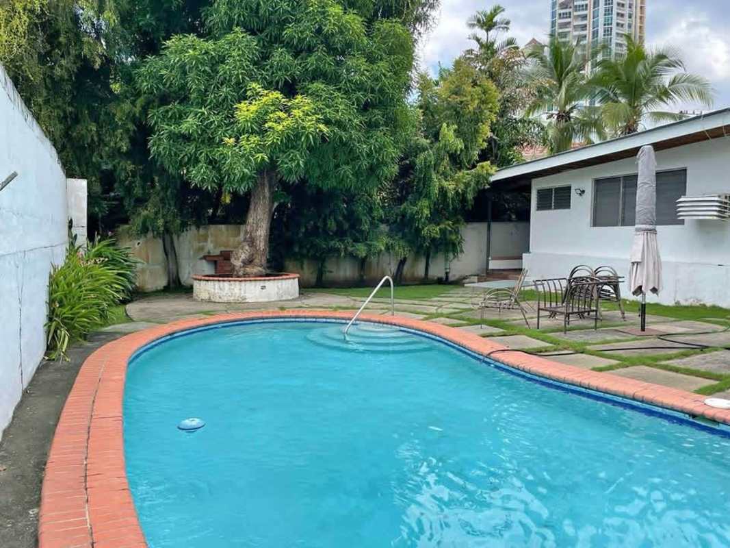 Swimming pool, patio seating, mature tree at commercial house for sale San Francisco Panama