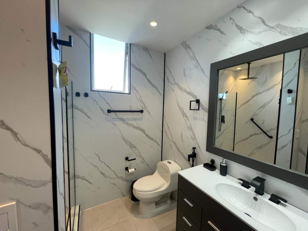 Bathroom with marble pattern tiles and glass shower PH Torres de Toscana Panama City
