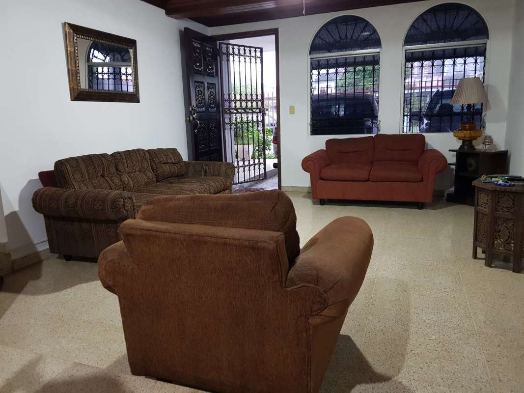 Living room featuring arched windows, sofas, traditional decor Betania Panama house