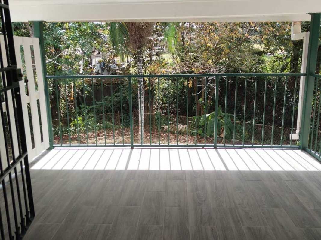 Balcony with metal railing overlooking lush gardens at Clayton Park Panama