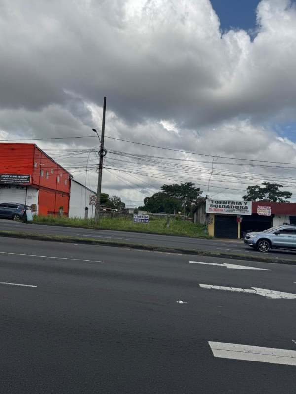 Visible commercial lot with paved road, adjacent warehouses and cloudy sky in Panama