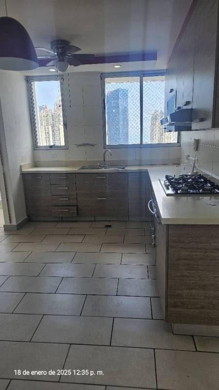Kitchen with large windows, gas cooktop, light wood cabinets and city view at Pacific Coast Panama