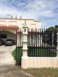 Large living room with high ceiling, ceramic tile floors and chandelier in Residencial Miramar house Santiago Panama