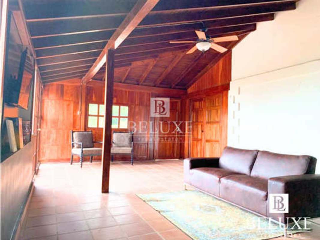 Rustic living room with wood beams, natural light and ceiling fan in Cerro Azul
