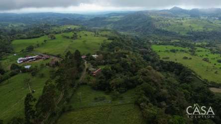 Wide aerial of pasture, wooded zone and distant mountains Cordillera Panama land for sale