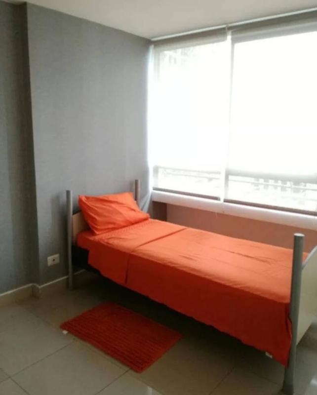 Minimalist bedroom with orange bedding window city view PH Citrus San Francisco Panama