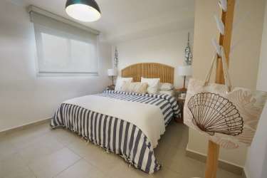Coastal decor bedroom with striped bedding and large window Punta Chame Playa Caracol Panama.