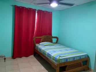 Bedroom with blue walls, ceiling fan, red curtains Platinium Park Panama