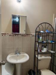 Small bathroom pedestal sink shelving beige tiles Platinium Park Panama