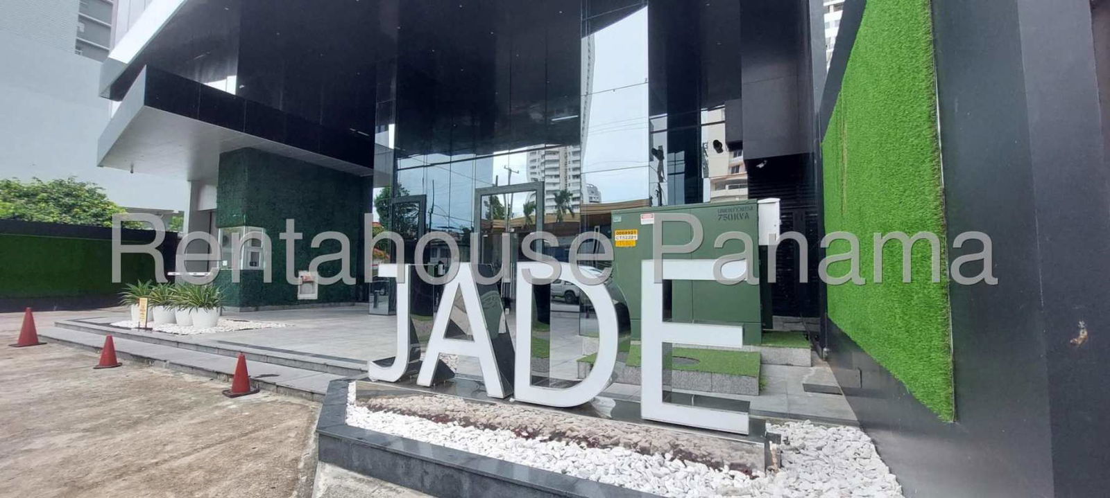 Luxury apartment building entrance PH Jade with glass facade and greenery in San Francisco Panama City