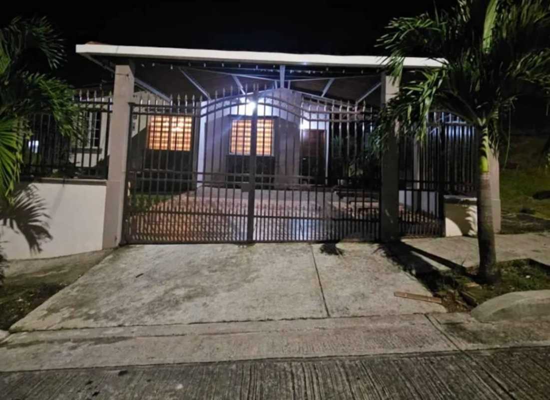 Secure front with metal fence, porch, carport and illuminated windows in Villa Lucre Panama
