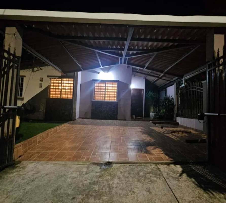 Front yard with metal fence, stone accent wall and night lighting in Vista del Valle Villa Lucre Panama