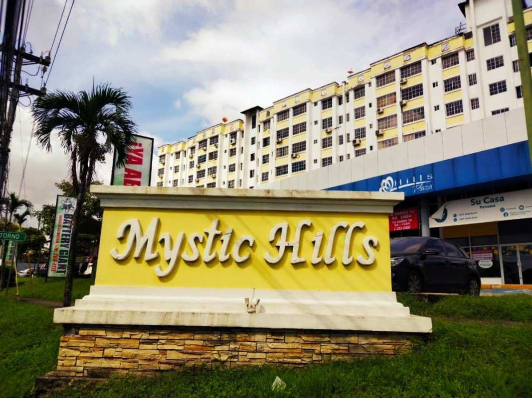 Exterior of apartment complex PH Mystic Hills with retail shops and signage in Panama City