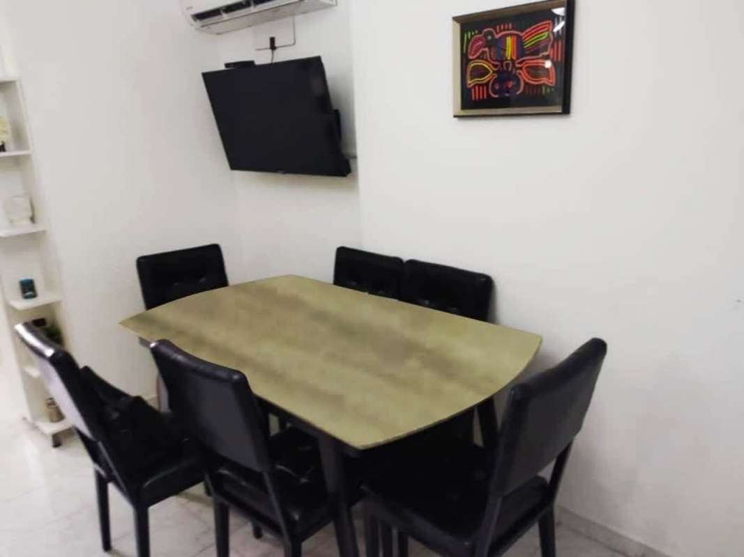 Dining area with black chairs, wall art, TV and AC PH Mystic Hills San Miguelito