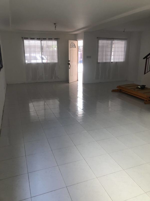 Spacious living room with tile floors and windows in two-story house in Quintas de Villa Flor San Antonio Panama