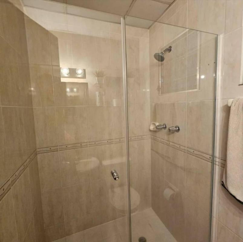 Contemporary tiled bathroom with glass enclosed shower in Villa Lucre Panama