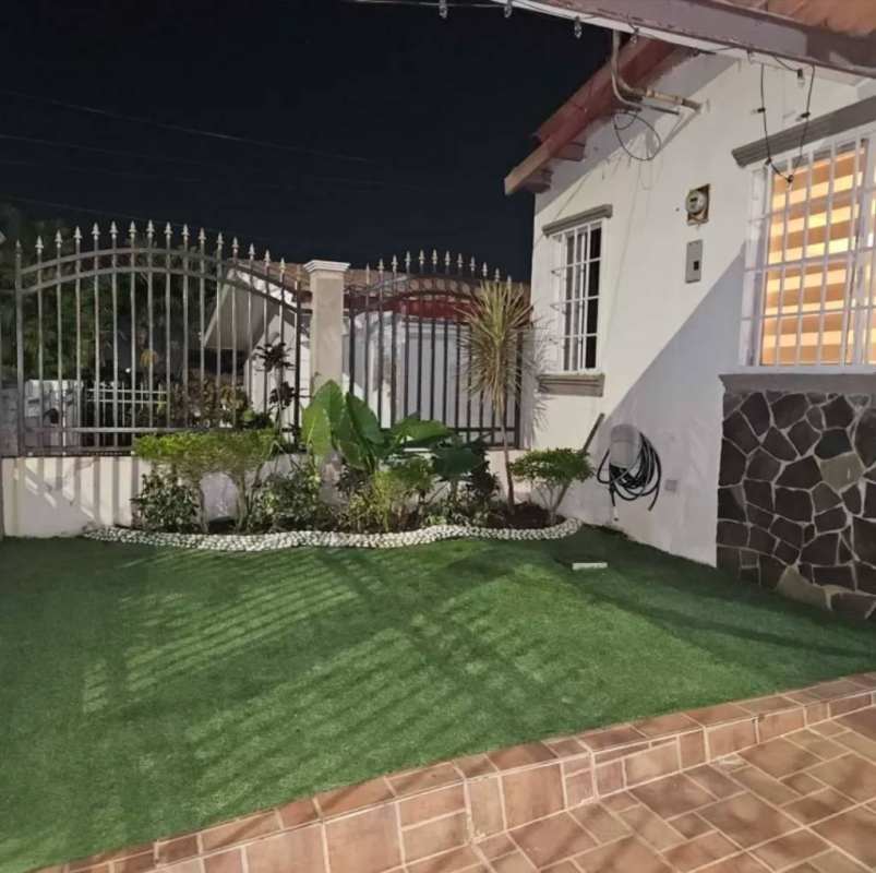 Night time view house exterior with fence landscaped yard in Villa Lucre Panama