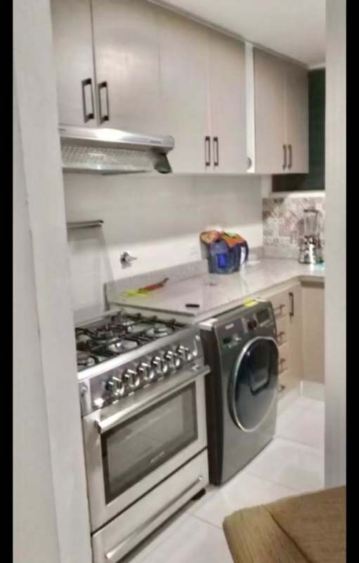 Compact open kitchen with laundry preparations, tile backsplash, in apartment for sale in Juan Diaz Panama