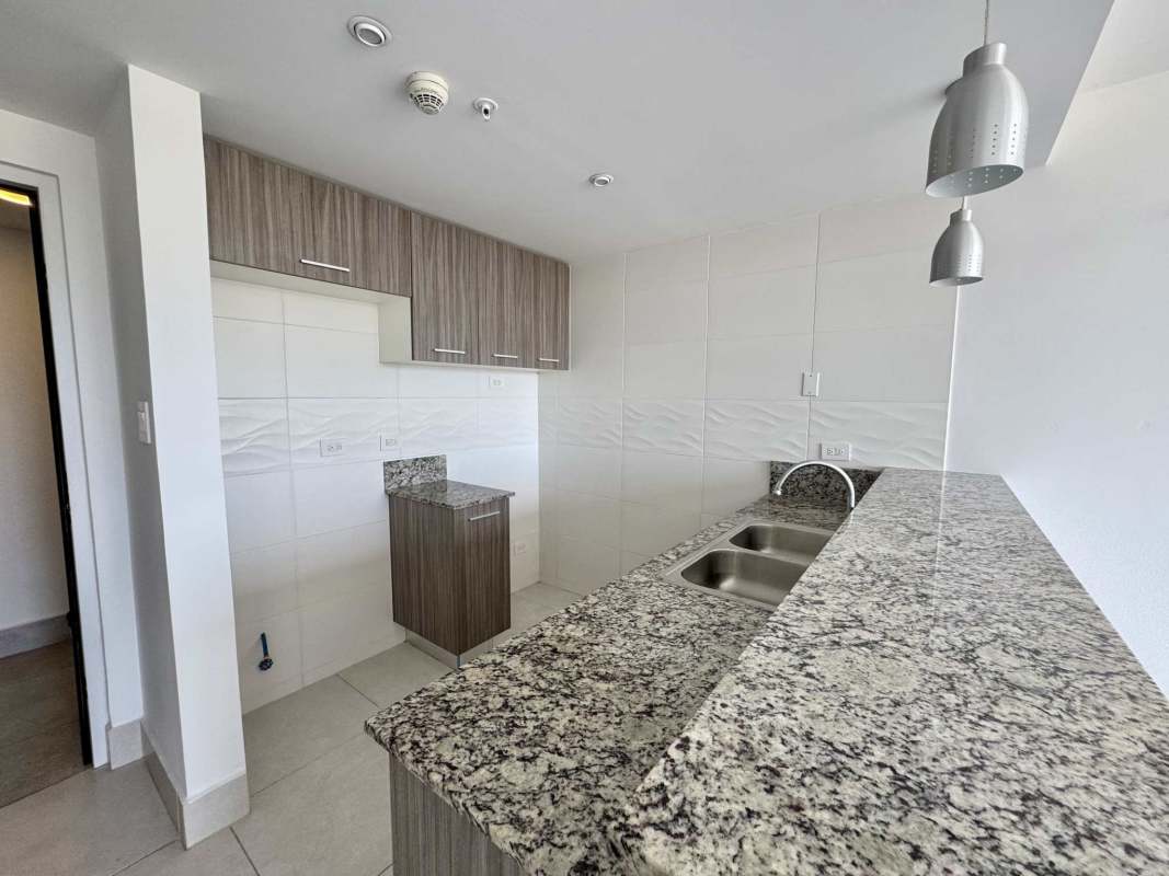 Modern kitchen with granite countertops, double sink, pendant lights in PH Greenwood Panama City