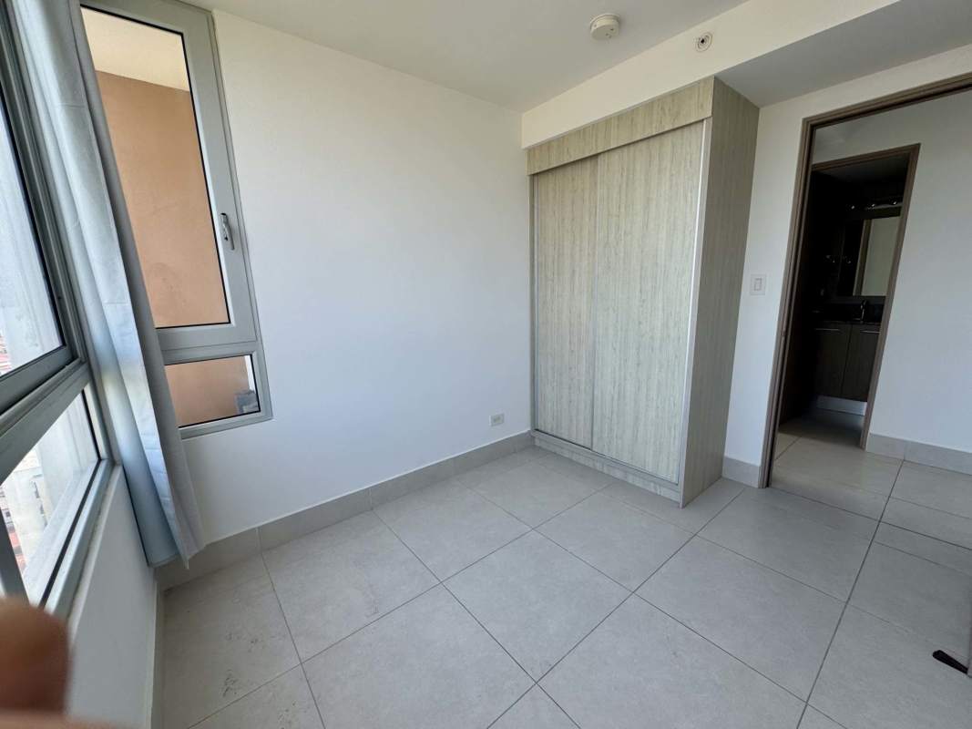 Spacious living room with city view through large windows at PH Greenwood Panama