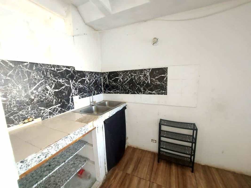 Basic kitchen with double stainless sink, marble pattern backsplash and tile floor PH Los Libertadores Panama