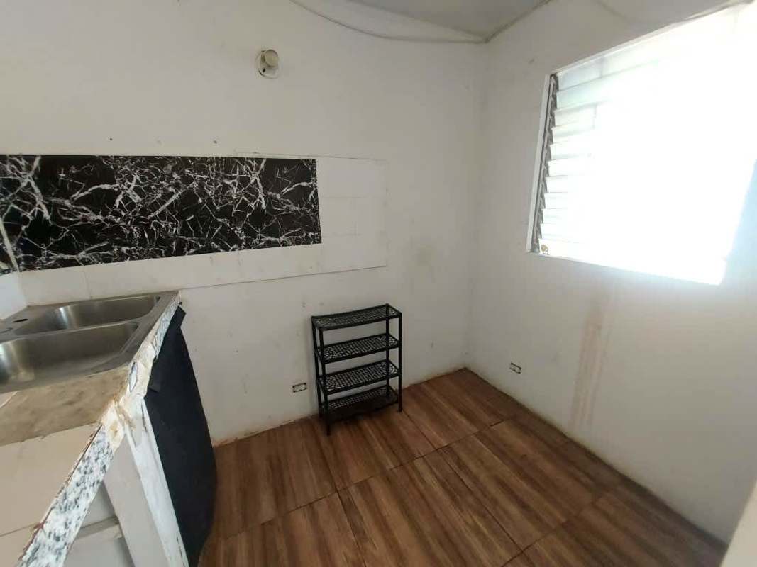 Basic apartment kitchen with marble backsplash, double sink and shelving in PH Los Libertadores Panama City