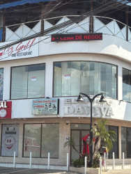 Two-story commercial complex with large windows glass railings balcony signage Santiago city center