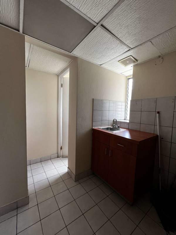Basic kitchenette with sink and cabinet inside commercial office Edificio Proconsa