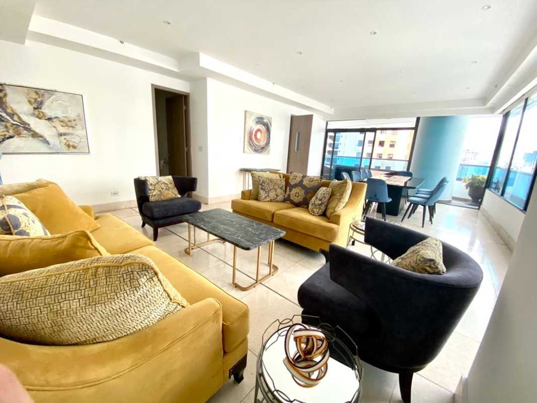 Open concept furnished living dining area mustard sofas modern art city views PH Punta Paitilla Panama City