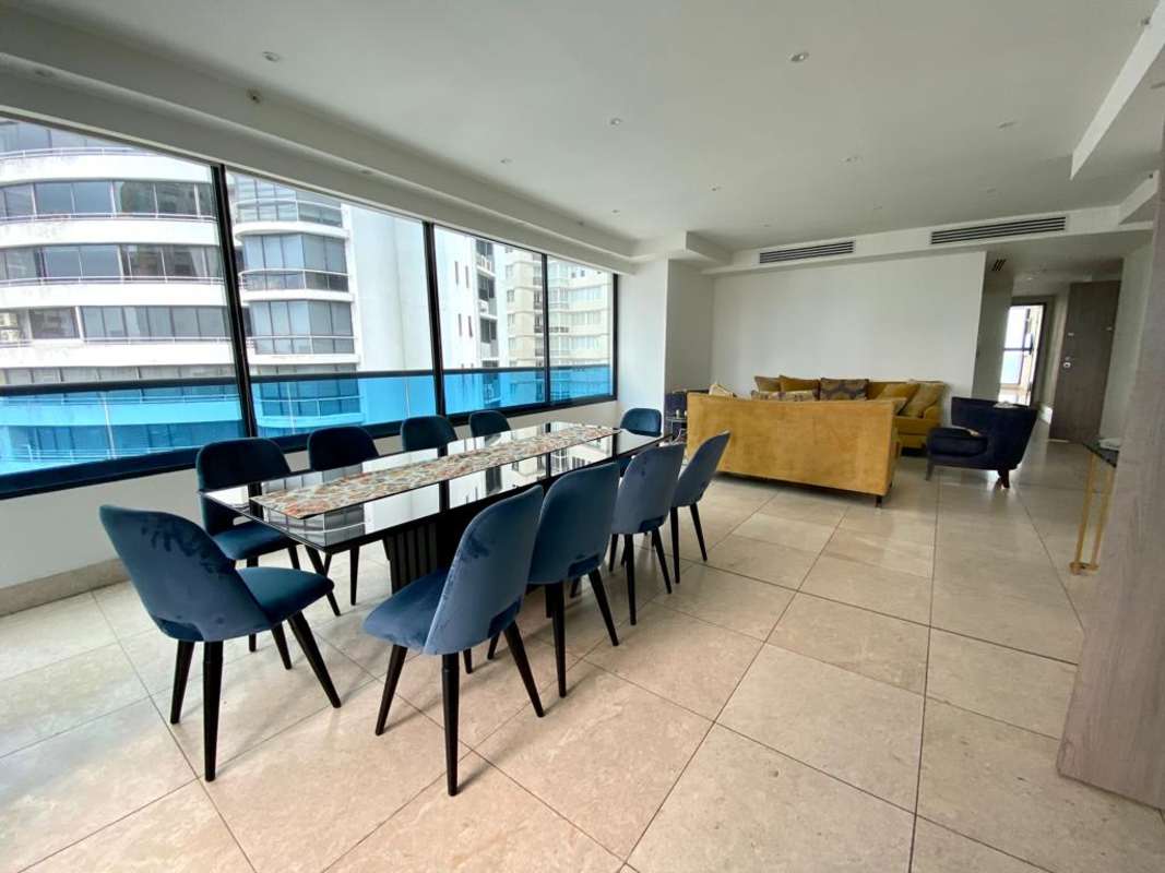 Modern living room with large windows mustard sofas and city views PH Punta Paitilla Panama