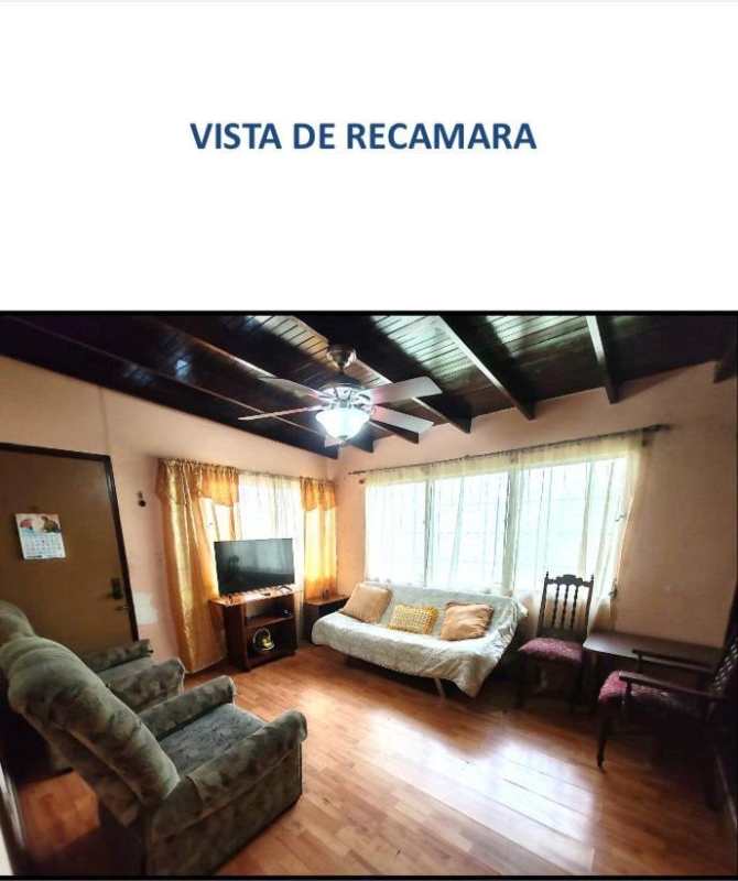 Bedroom with wood ceiling beams, window, and ceiling fan Villa Cáceres La Alameda