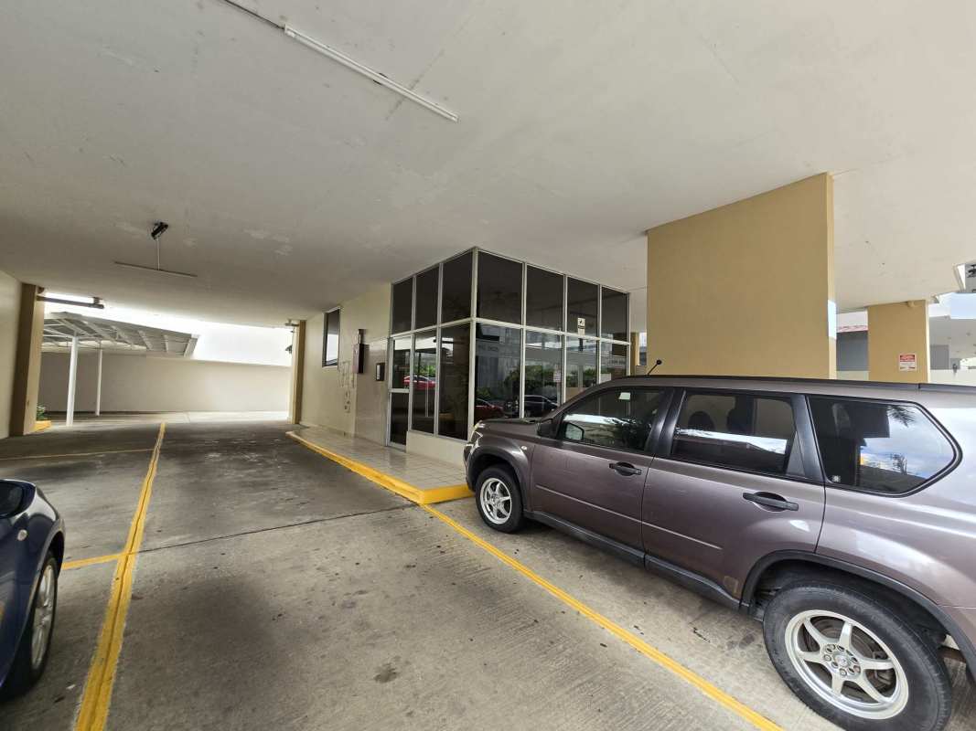 Covered parking garage with modern glass lobby entrance at PH Ocean View in San Francisco Panama