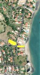 Aerial image of beachfront community in Coronado with highlighted residential lots near sandy shore