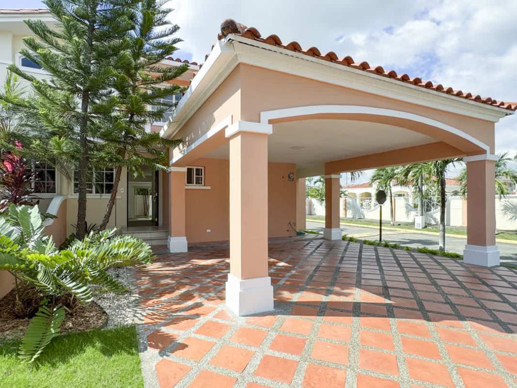 Villa Valencia house facade with covered carport, tile roof in Costa Sur Panama City