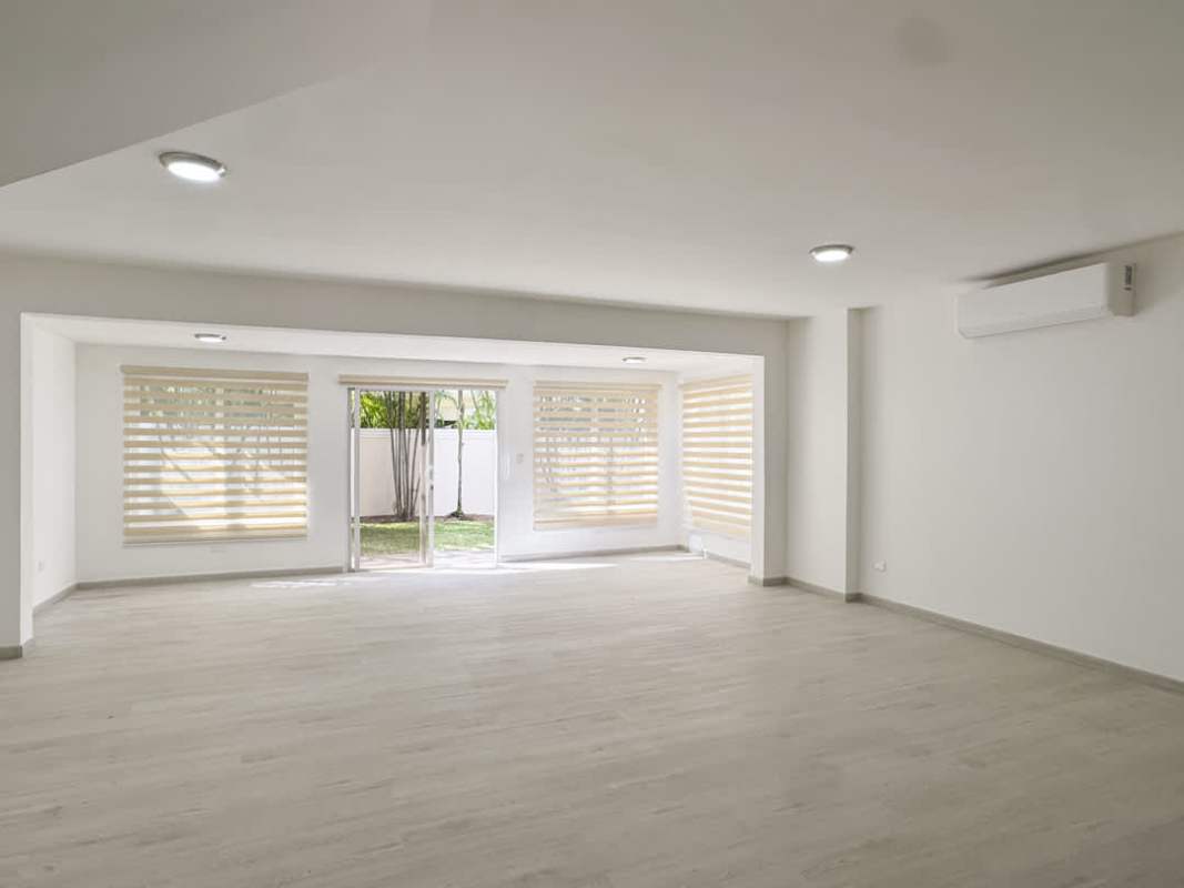 Spacious modern living room with large windows, split AC, wood flooring in house Villa Valencia Panama