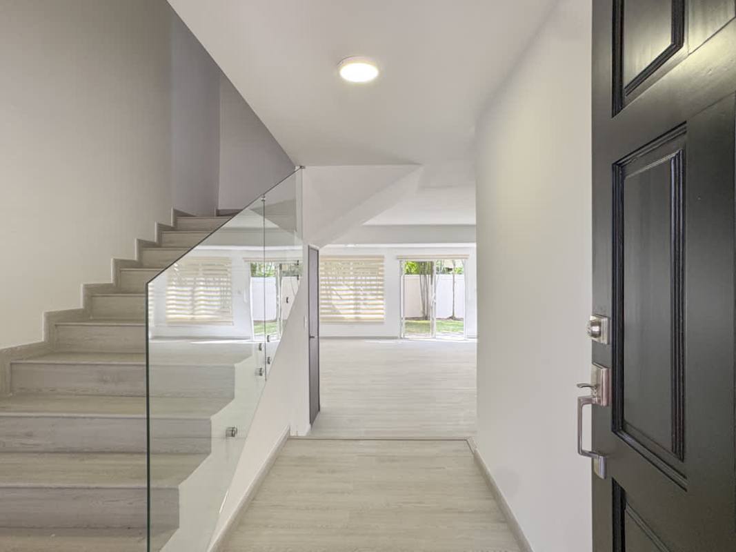 Contemporary open kitchen with wood cabinetry, island, stainless appliances in Costa Sur house Panama