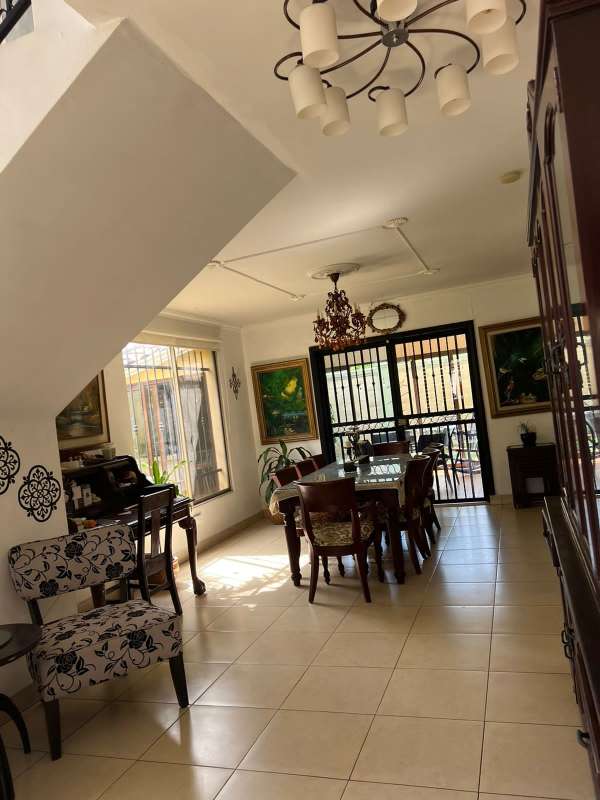 Spacious dining room with chandelier and natural light near stairs Paseo Dorado house Panama City